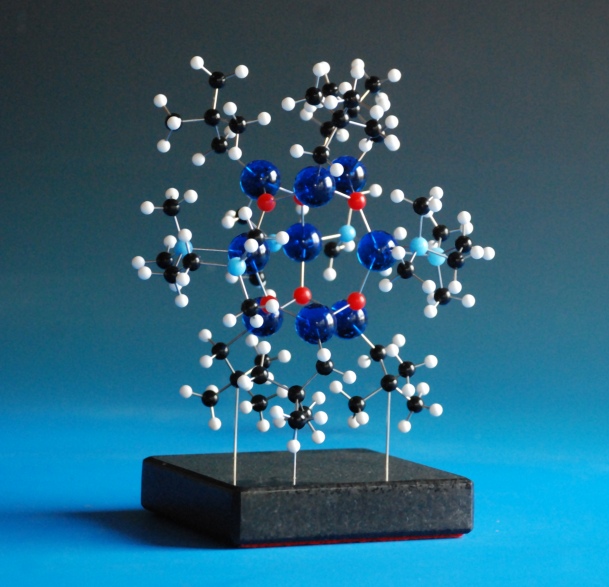 A ball and stick molecular model of a symmetrical metal complex on a granite base