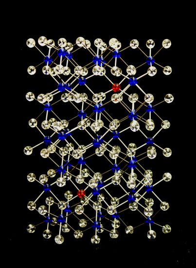 A crystal structure model of the gemstone mineral ruby (chromium doped alumina) made with transparent clear, red and blue acrylic balls and metal rods